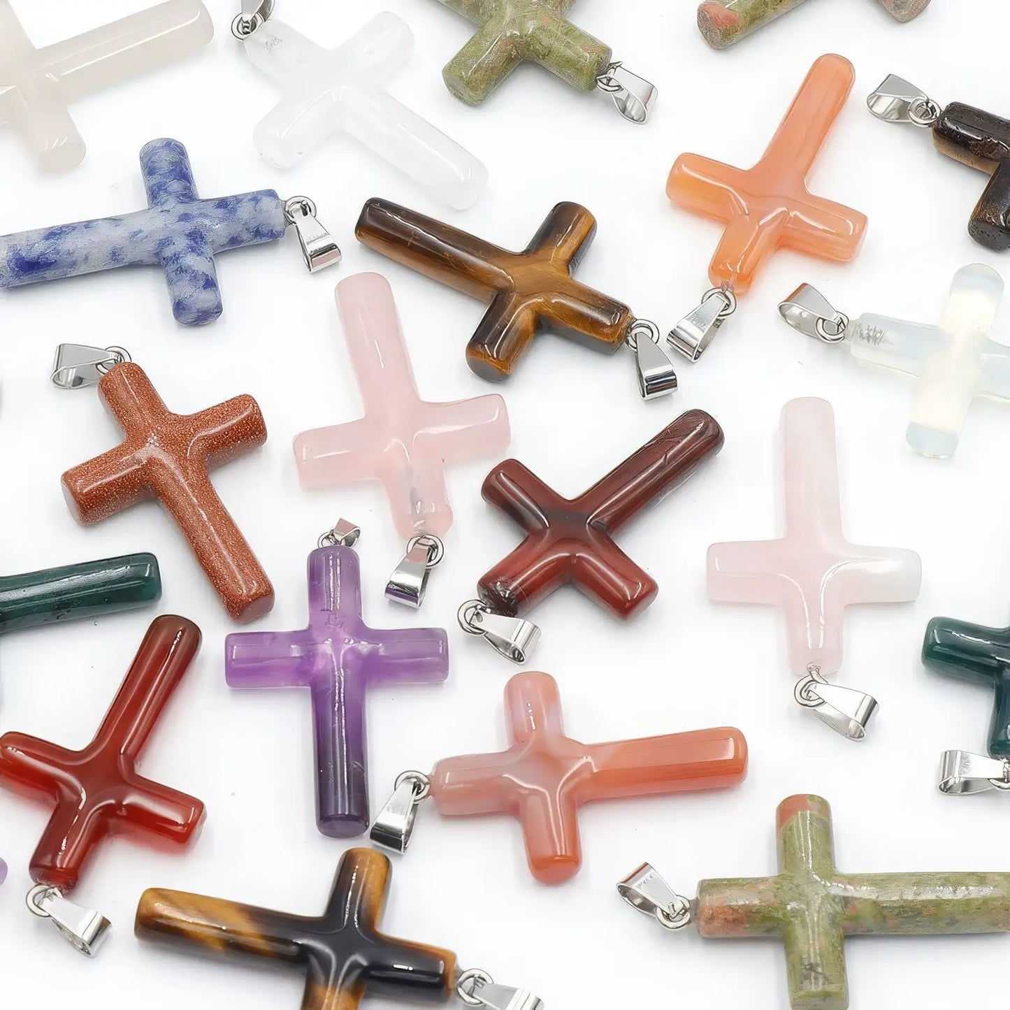 Set of various agate and semi - precious stone cross pendants in different colors.