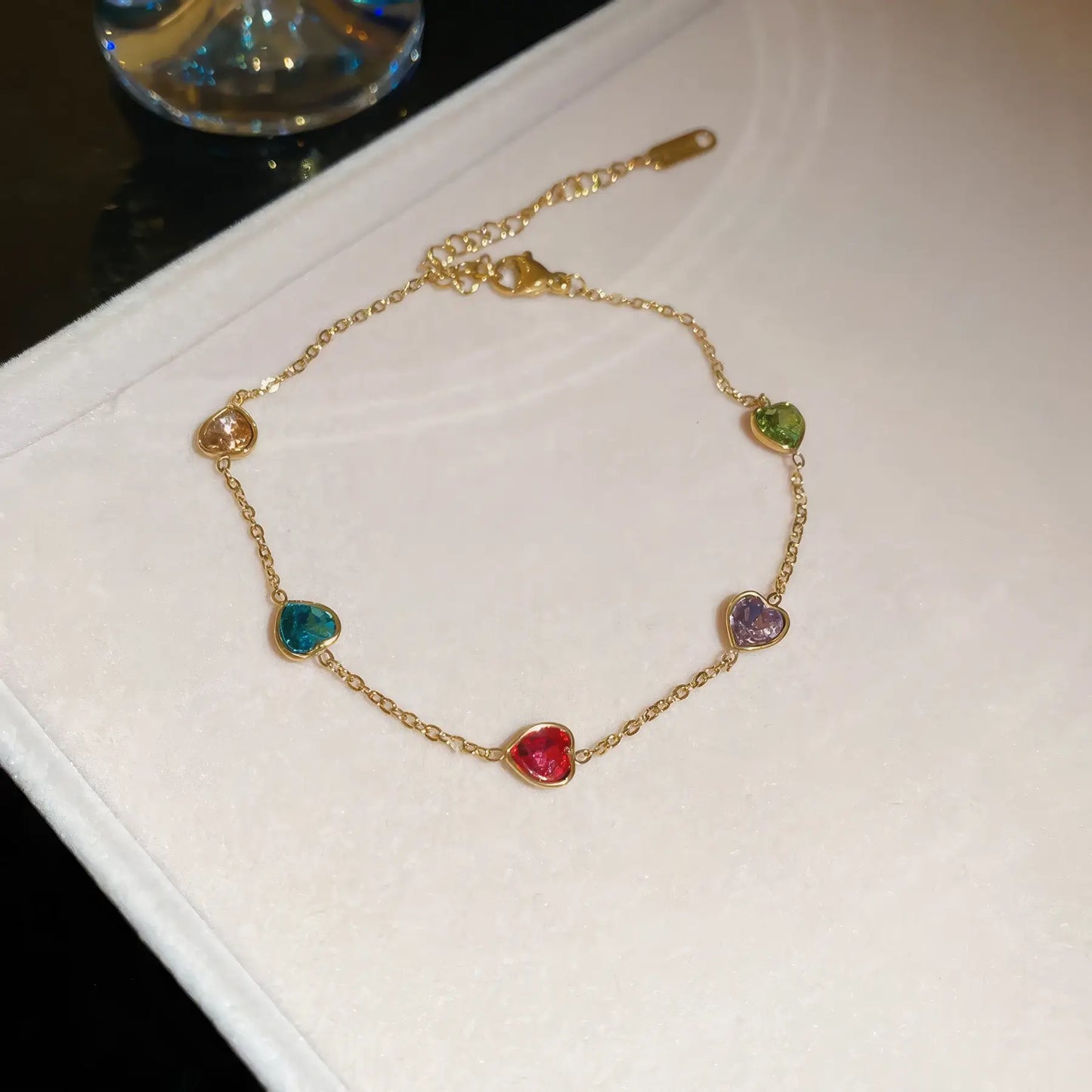 Colorful heart bracelet placed on a light - colored surface.