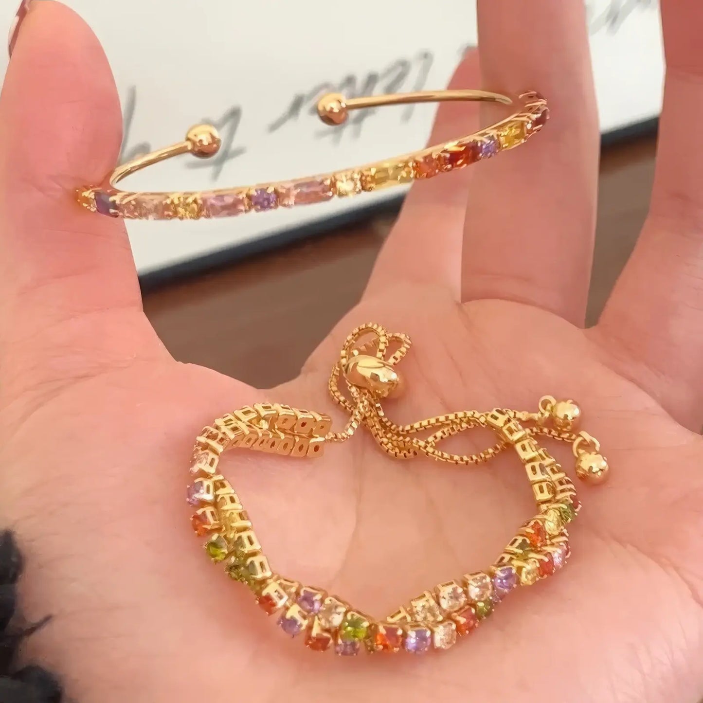 Colorful zircon twisted bracelet and an adjustable - style bracelet held in hand.
