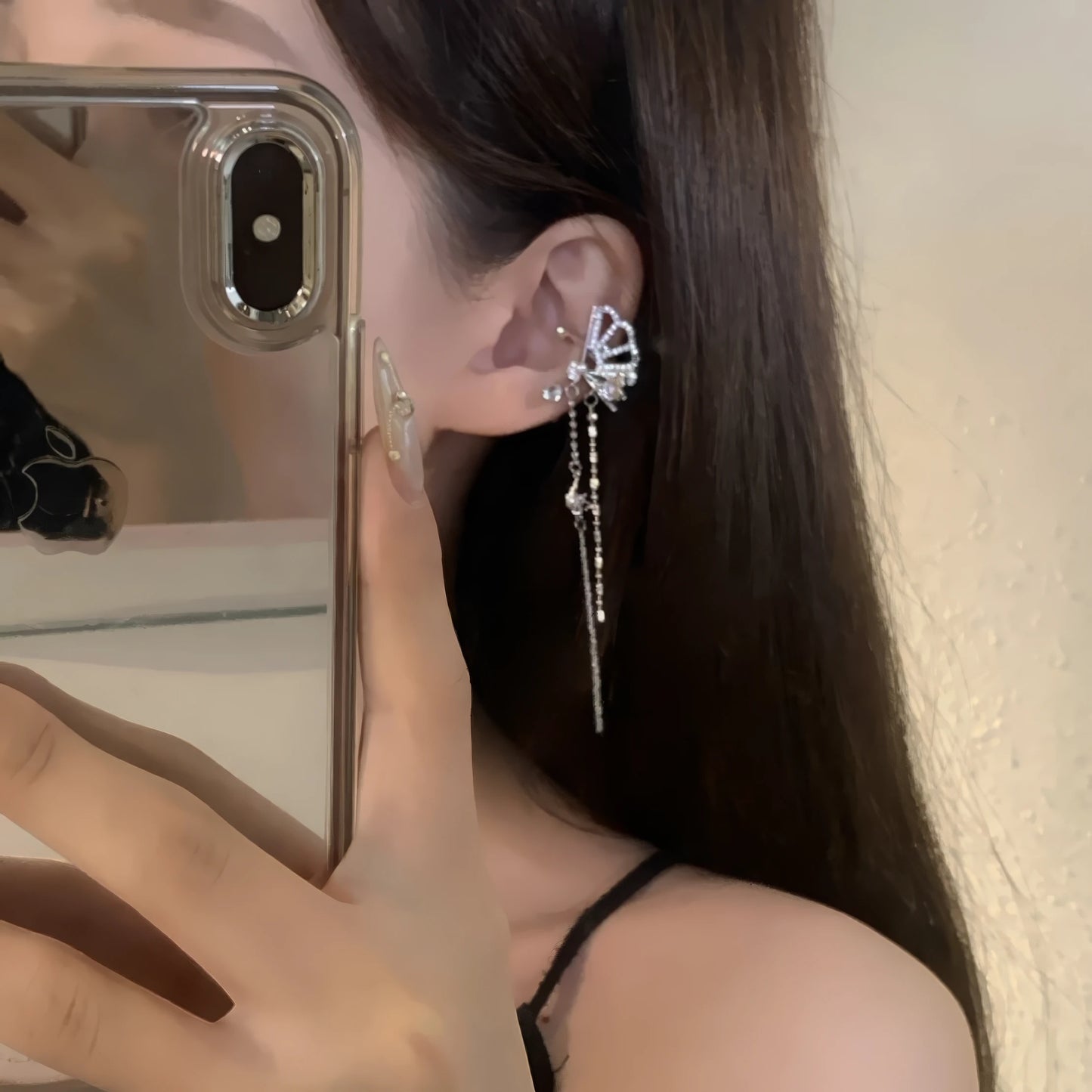 Fan - shaped tassel ear clips worn, person taking a selfie with phone, showcasing the elegant, sparkling design with dangling tassels.