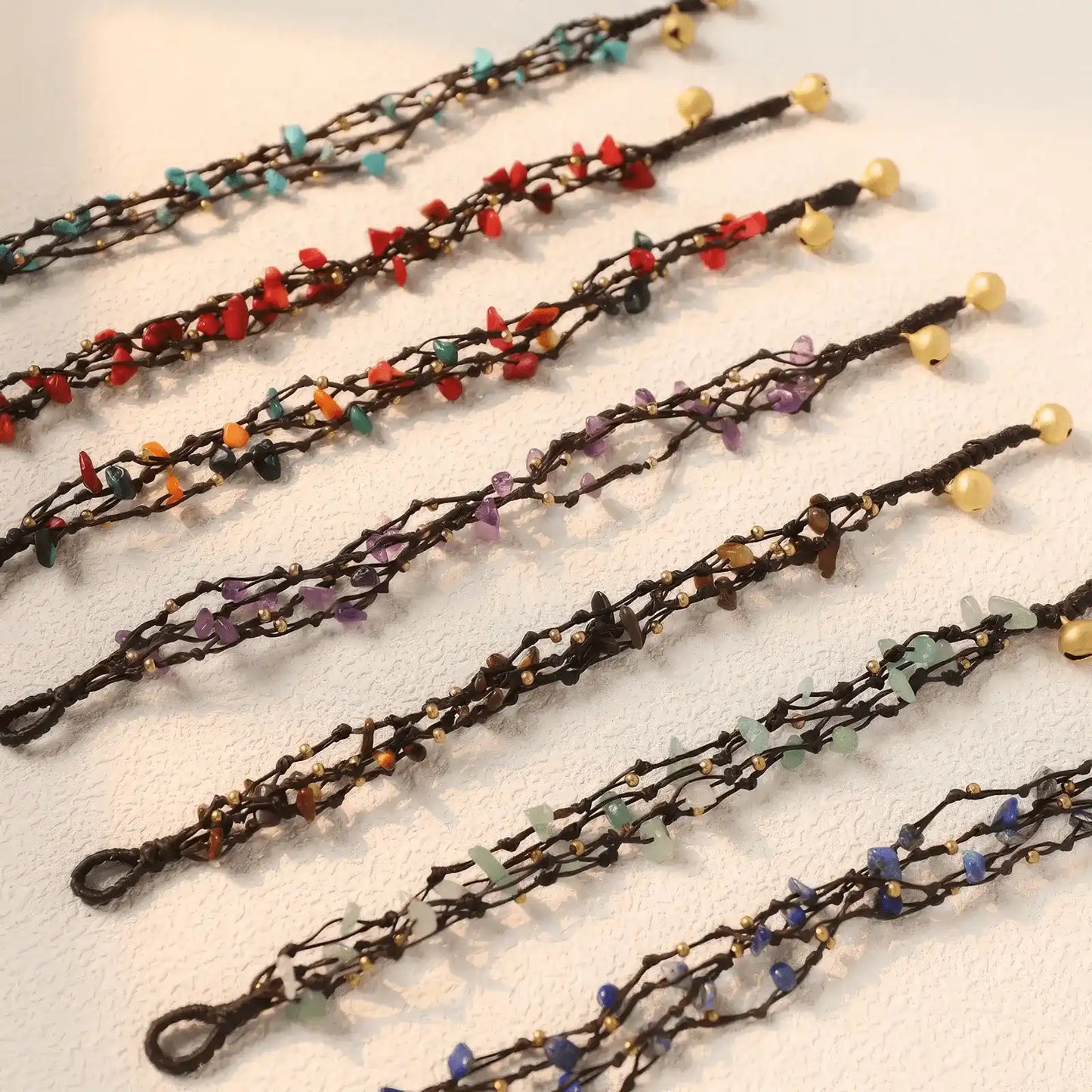 Assortment of forest - style retro crystal bracelets in various colors, laid out on a surface.