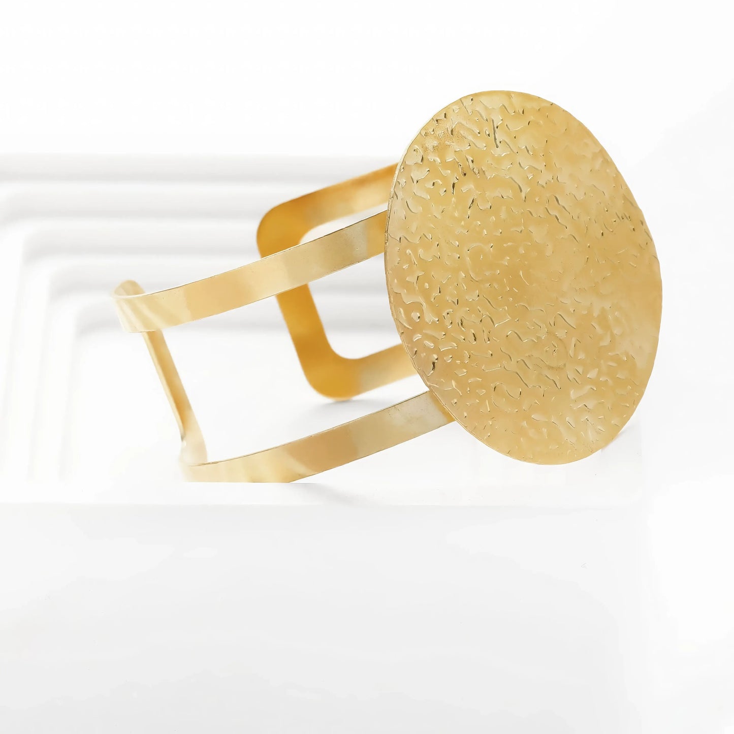 Gold - toned metal bracelet with round accent.