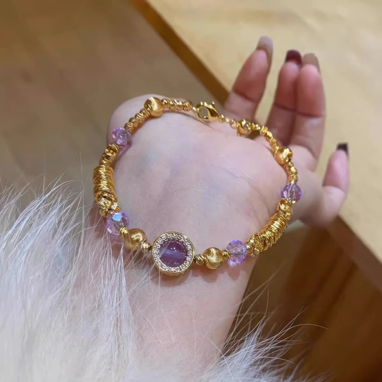 Purple star bracelet placed on hand, emphasizing gold and purple details