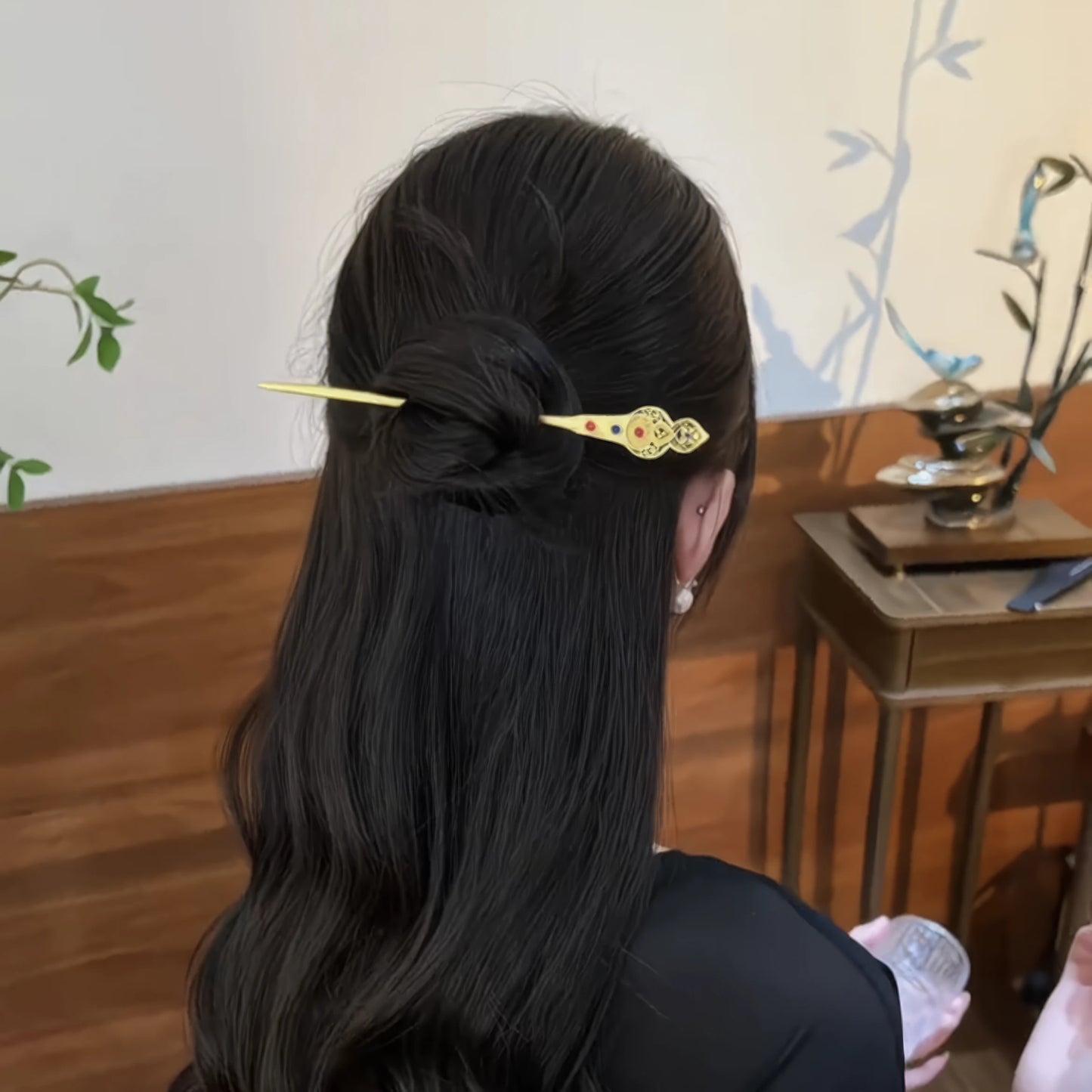 Gold auspicious gourd hairpin worn in a half - up hairstyle, traditional setting