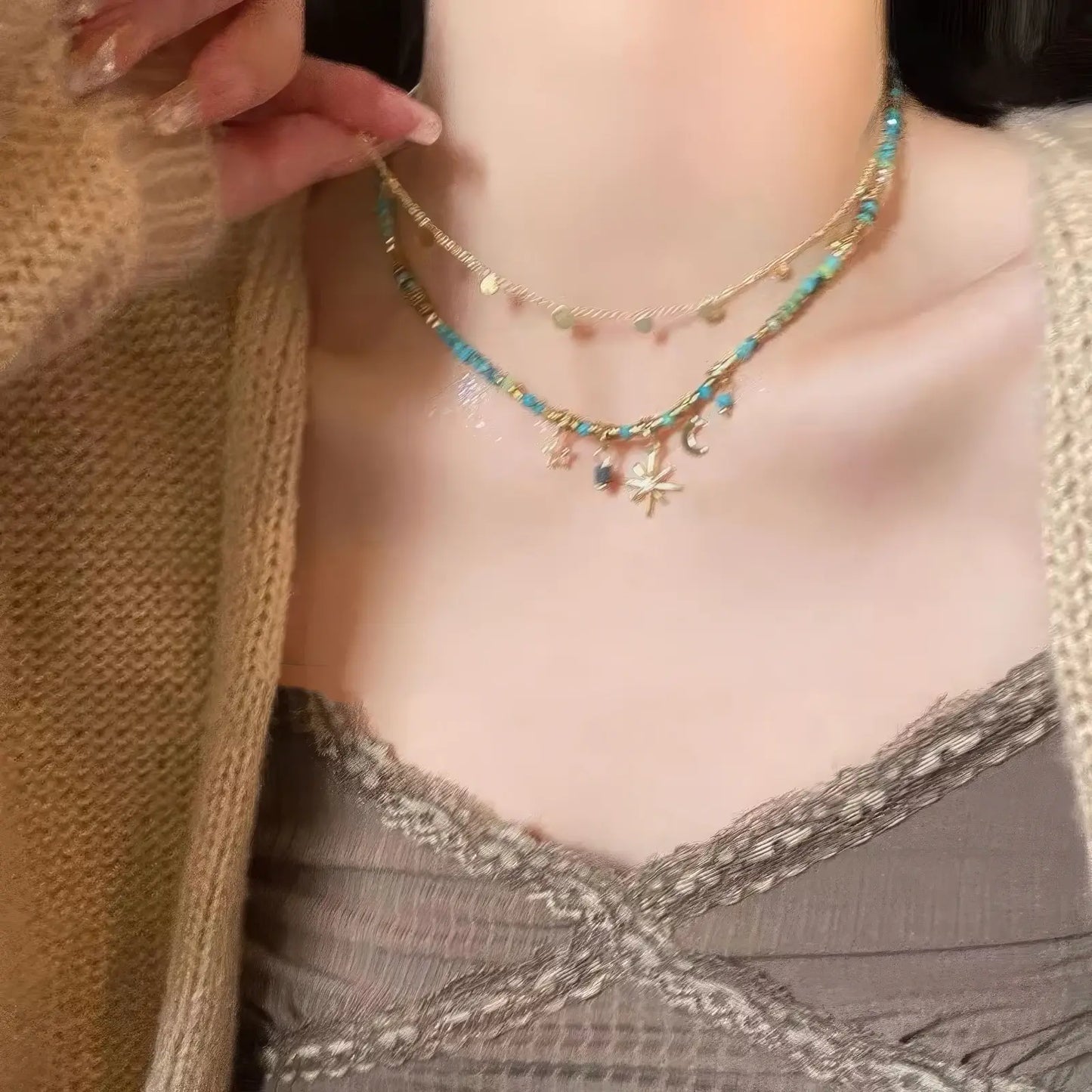 Blue star beaded layered necklace worn, complementing a gray lace top, showcasing elegance