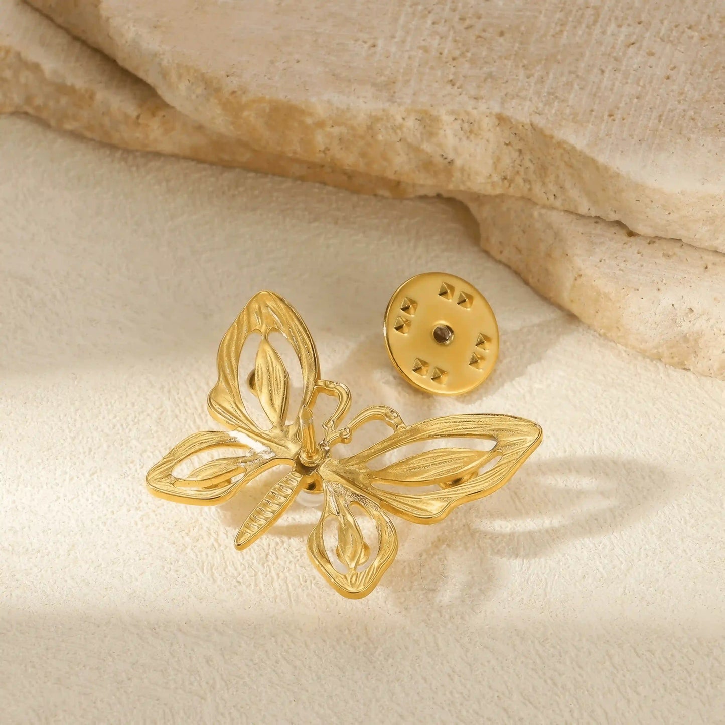 Back view of gold butterfly brooch, highlighting pin mechanism