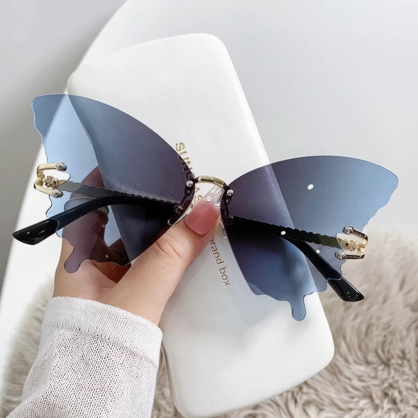 Butterfly - shaped sunglasses with blue lenses and rhinestone designs