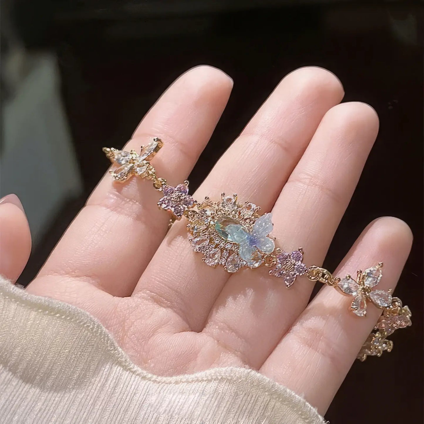 Hand holding butterfly zircon flower bracelet
