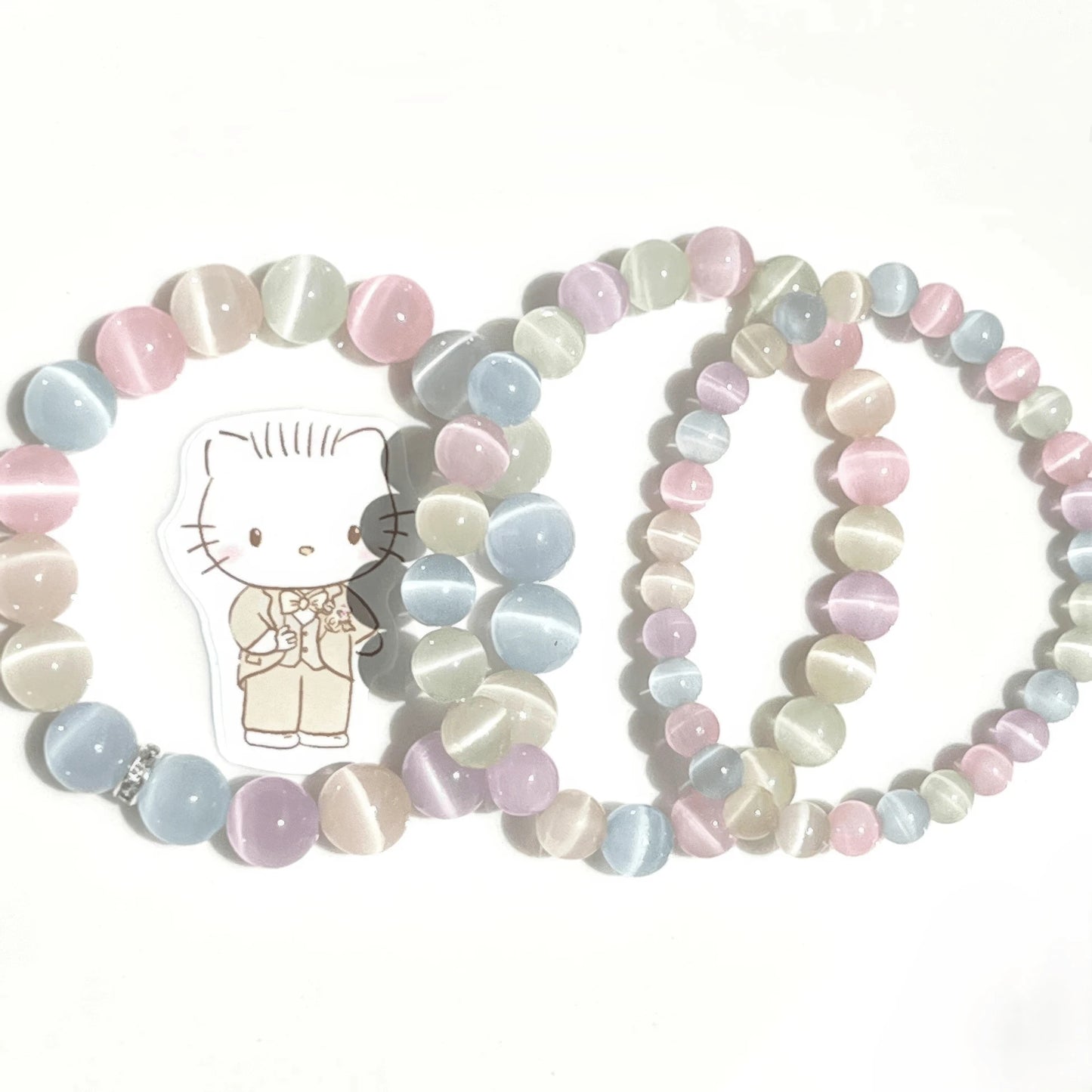 Colorful cat eye stone rainbow bracelets, paired with Hello Kitty charm, isolated on white