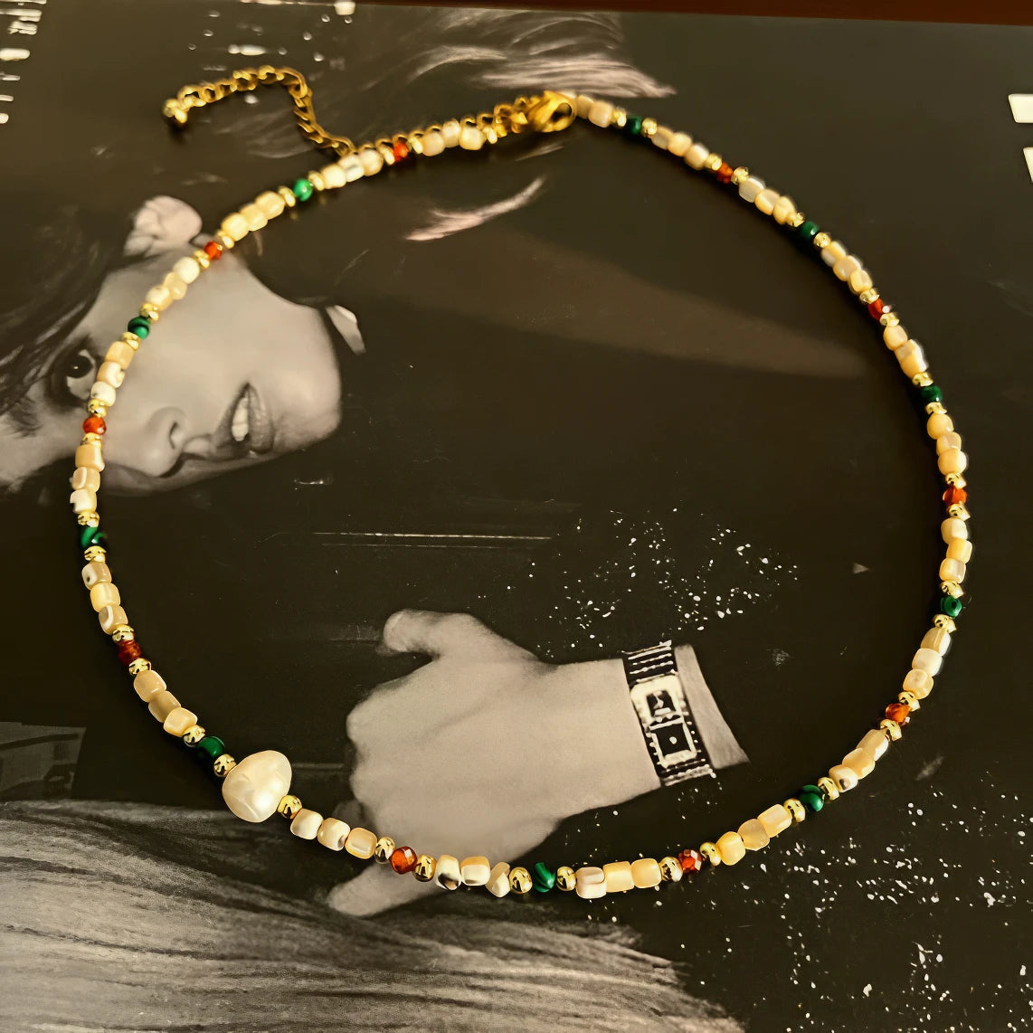 Colorful milky bead necklace, displayed on background with black - and - white photo