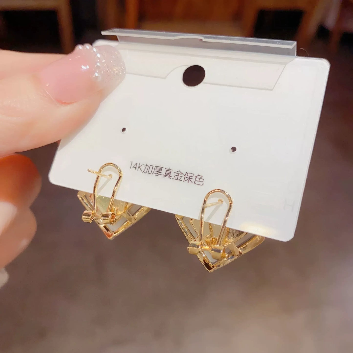 Back view of diamond - shaped cat - eye earrings on card, showing clip mechanism