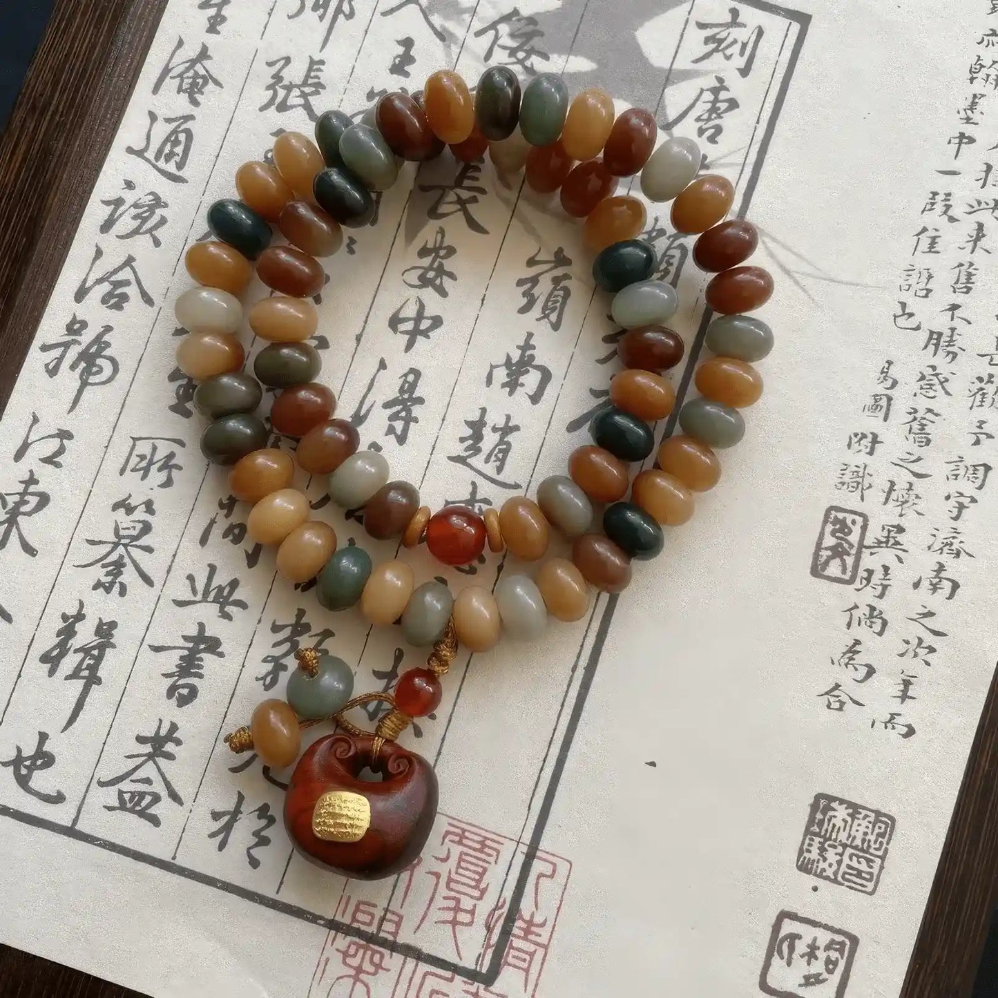 Dunhuang bodhi root bracelet placed on calligraphy paper, emphasizing cultural charm