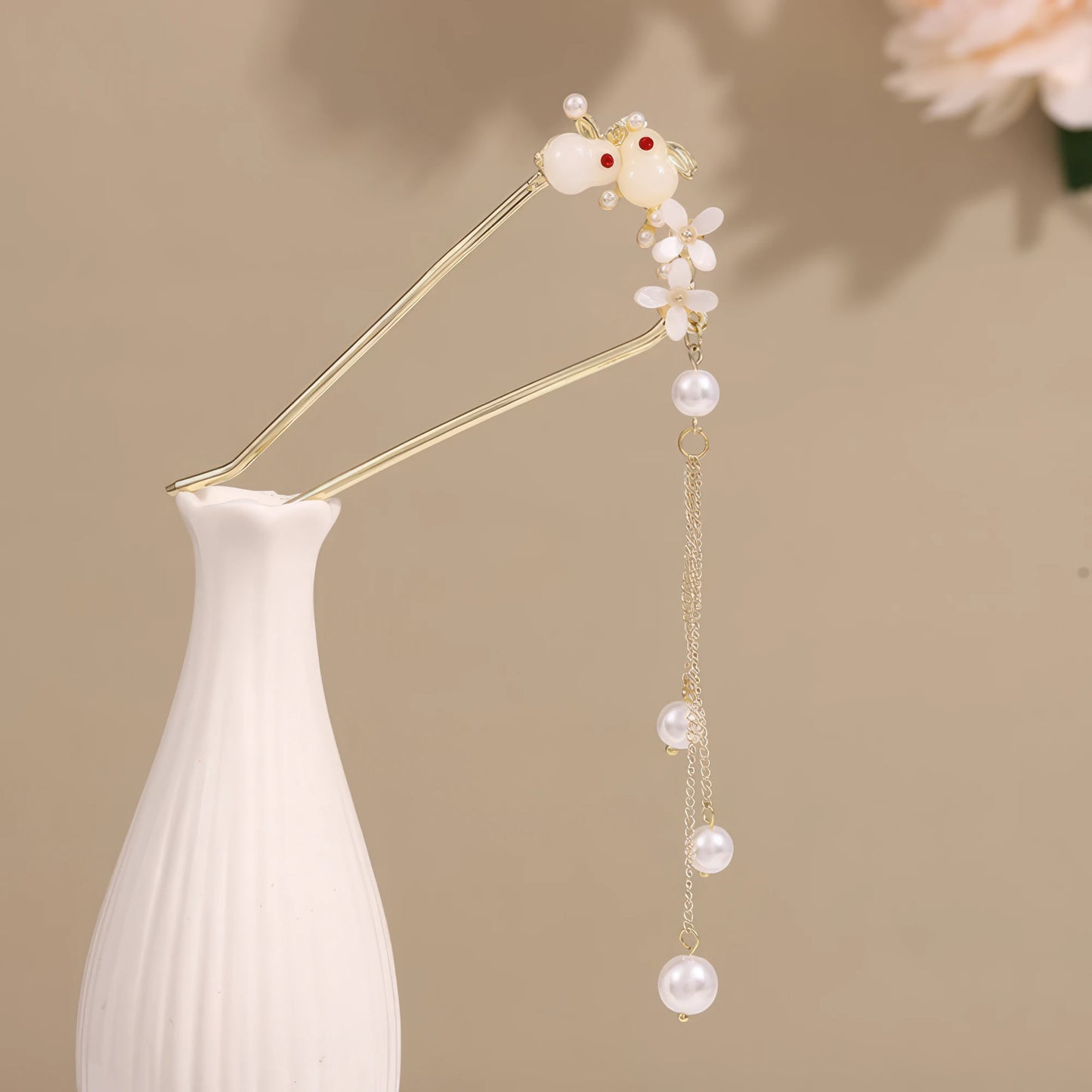 Fish tail U - shaped hairpin with pearl tassel, white vase on beige background