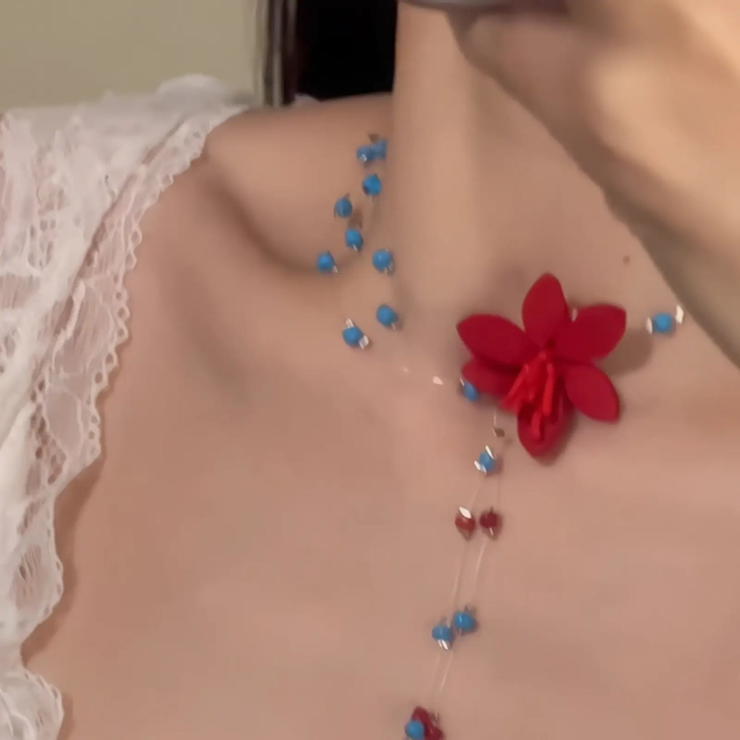Flower rice bead necklace, red flower with blue beads, worn on chest with white lace top