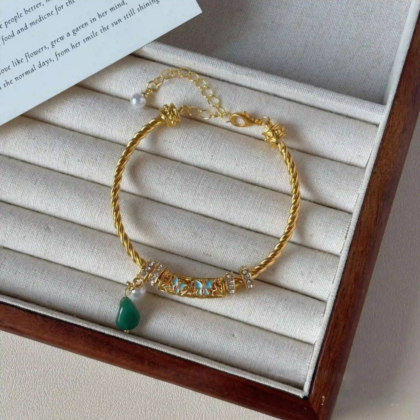 Glaze enamel twisted bracelet, gold - tone with green stone, displayed in jewelry box