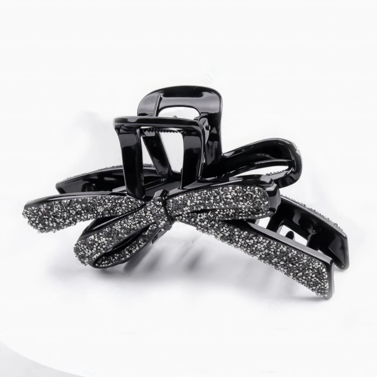 Glittering full diamond bow claw clip isolated on white background, top view
