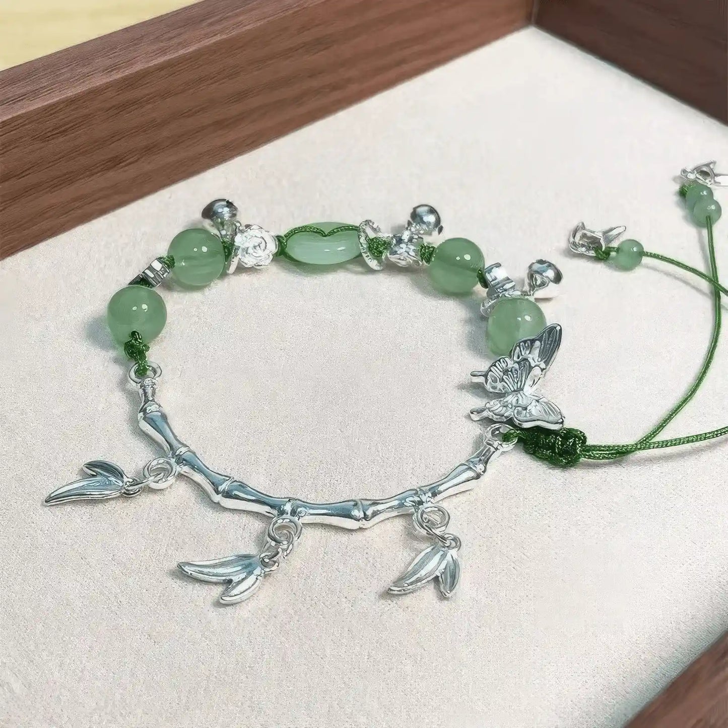 Green lotus butterfly bracelet placed on tray, showcasing design details