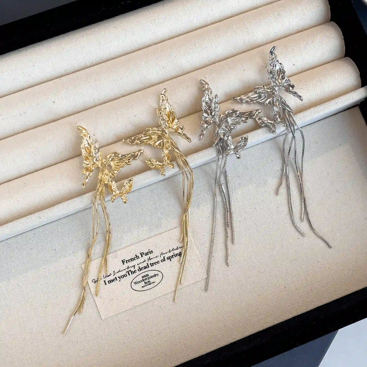 Mixed gold and silver butterfly tassel earrings in a jewelry box