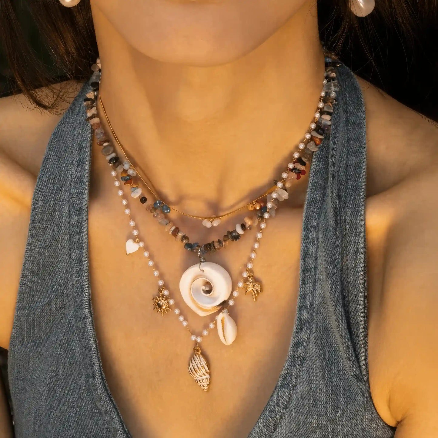 Natural shell beaded pendant necklace worn, emphasizing design with blue top