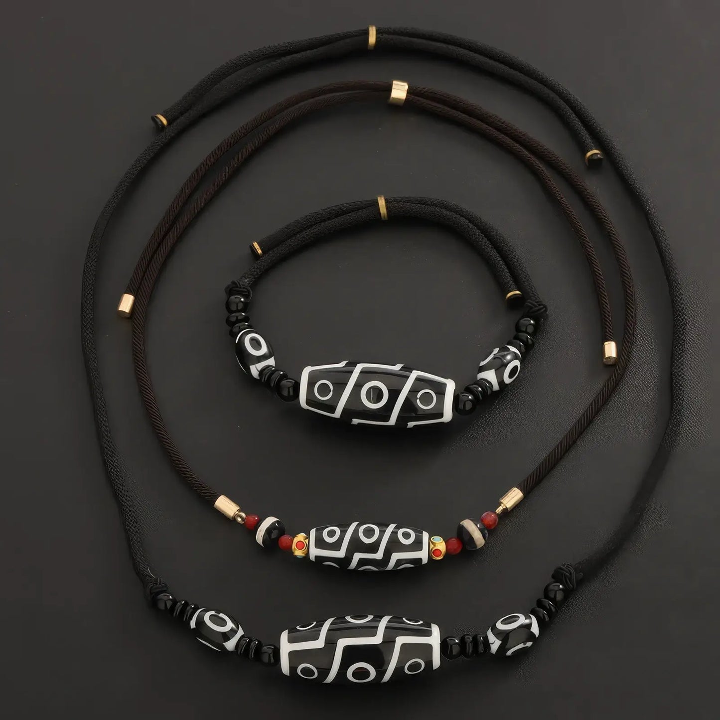 Set of new Chinese style dzi bead necklaces, showcasing different sizes and designs, isolated on black background