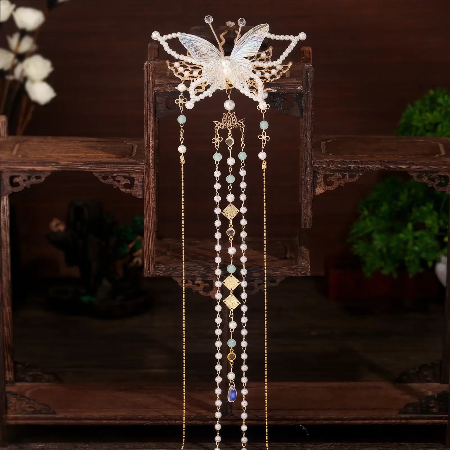 A fourth pearl - adorned butterfly tassel hairpin with a number 4 in the bottom - right corner on a solid - color countertop background