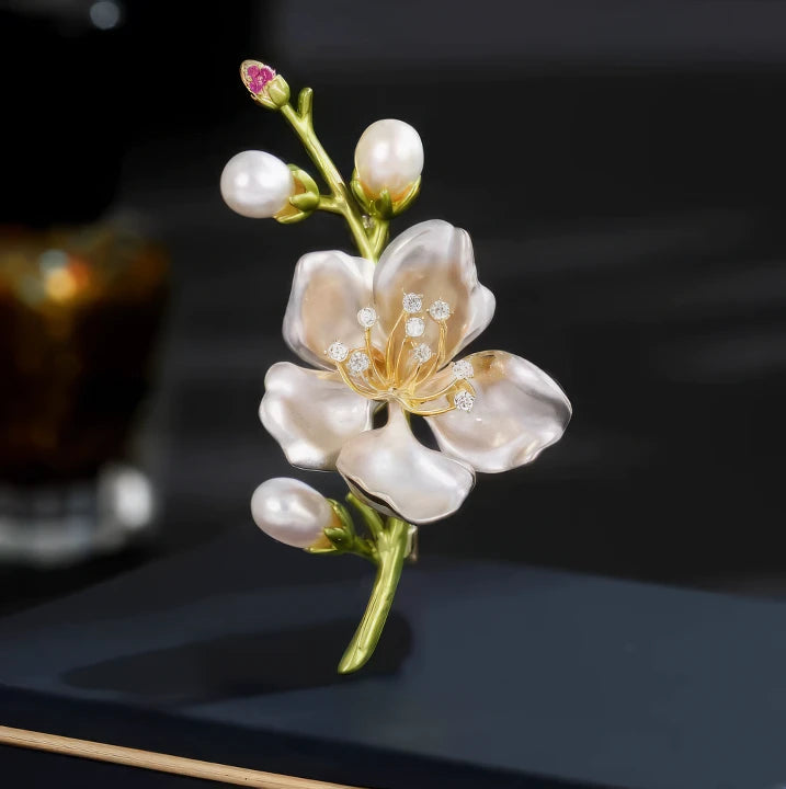 White pearl magnolia brooch with buds, displayed on dark background