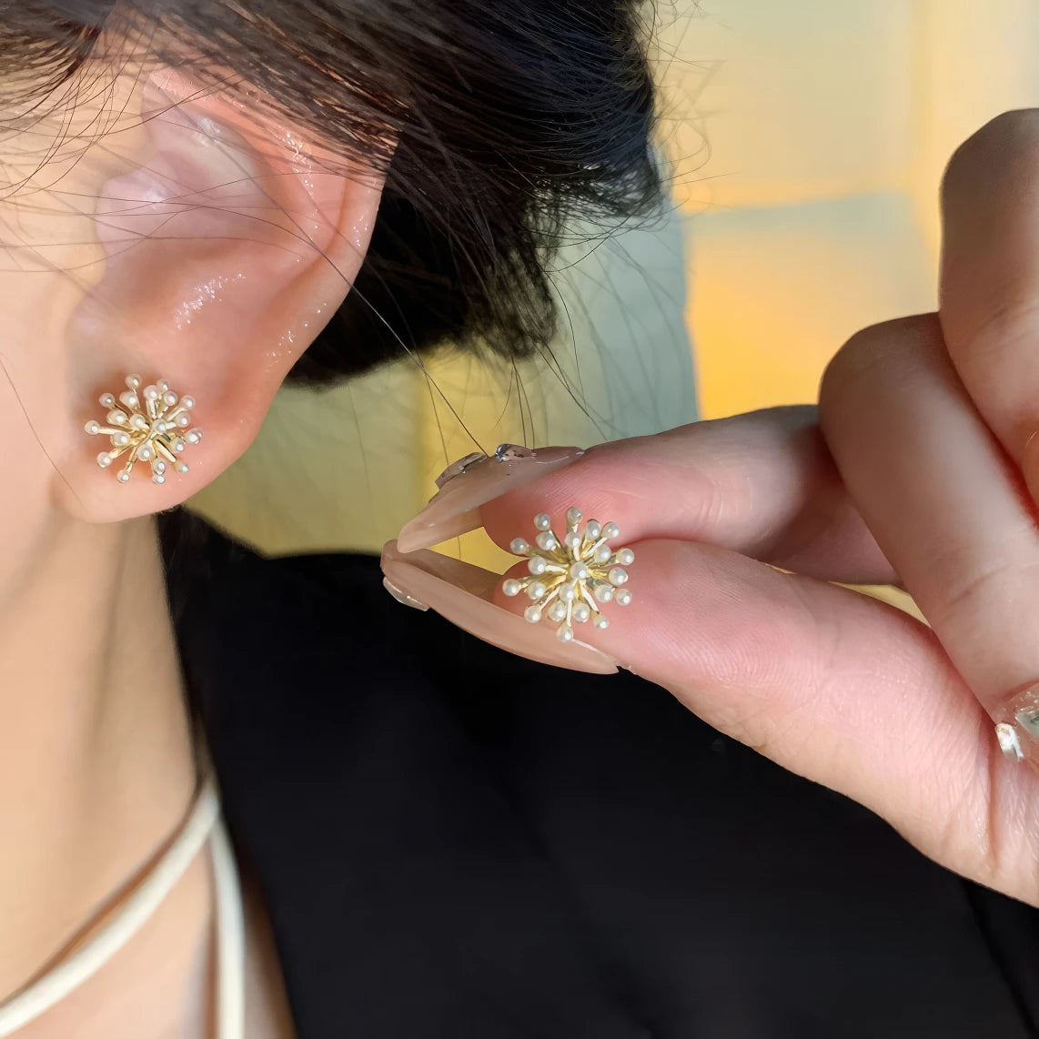 Pearl popcorn earrings worn on ear, hand showcasing, underlining style
