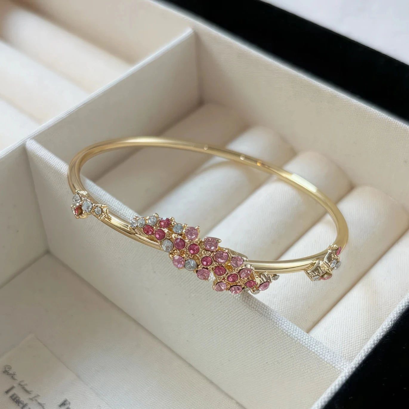 Pink flower wrapped bangle placed in a white jewelry box
