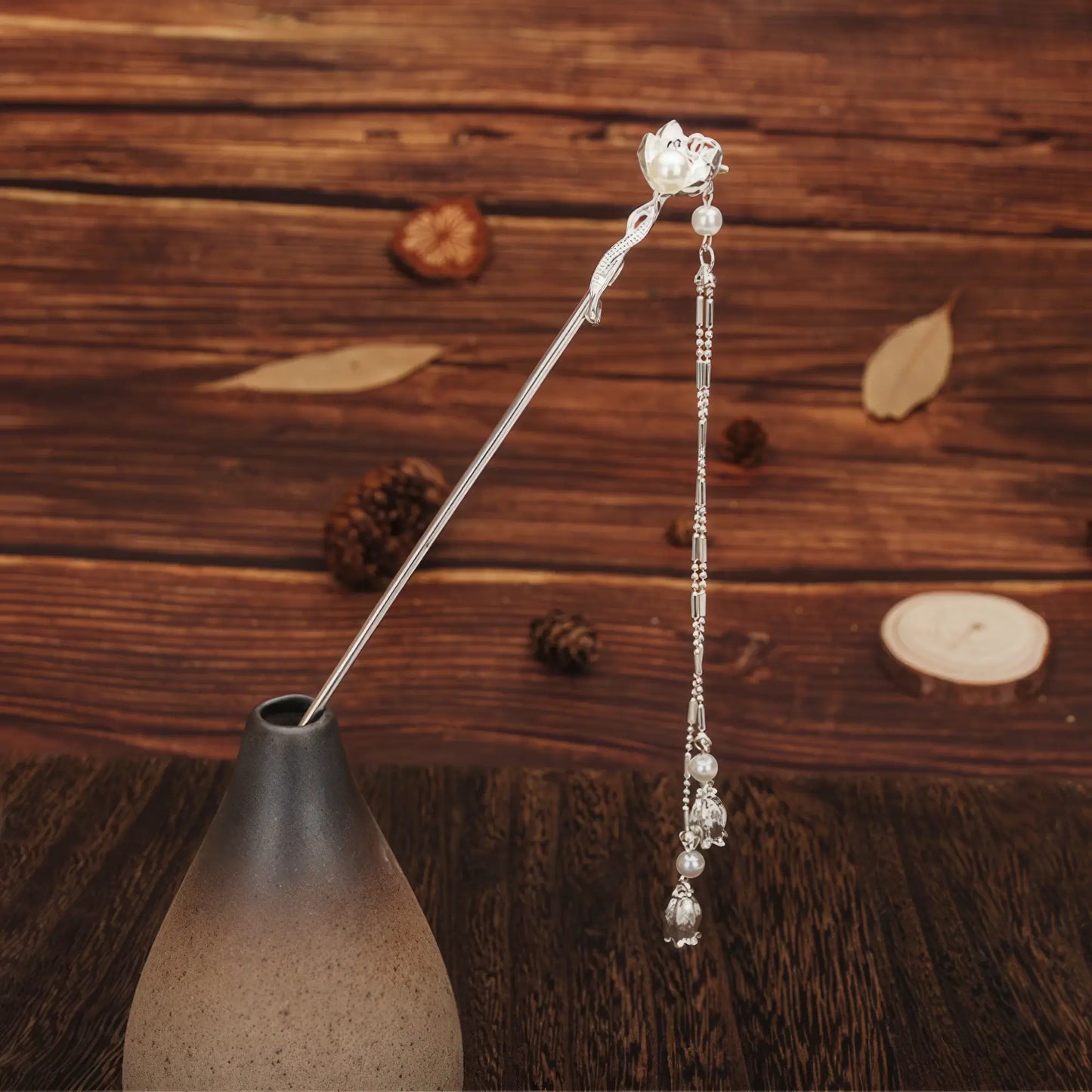 Qimei silver hairpin with flower and tassel on wooden background