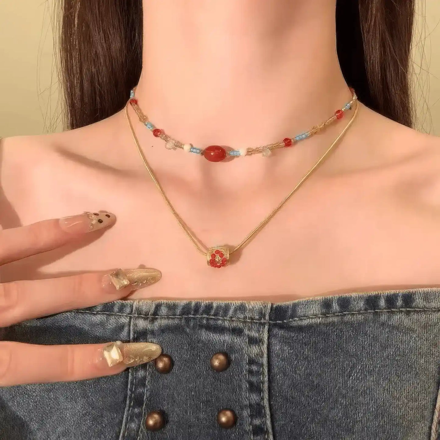 Red agate beaded pendant necklace worn, highlighting the layered look with a denim top