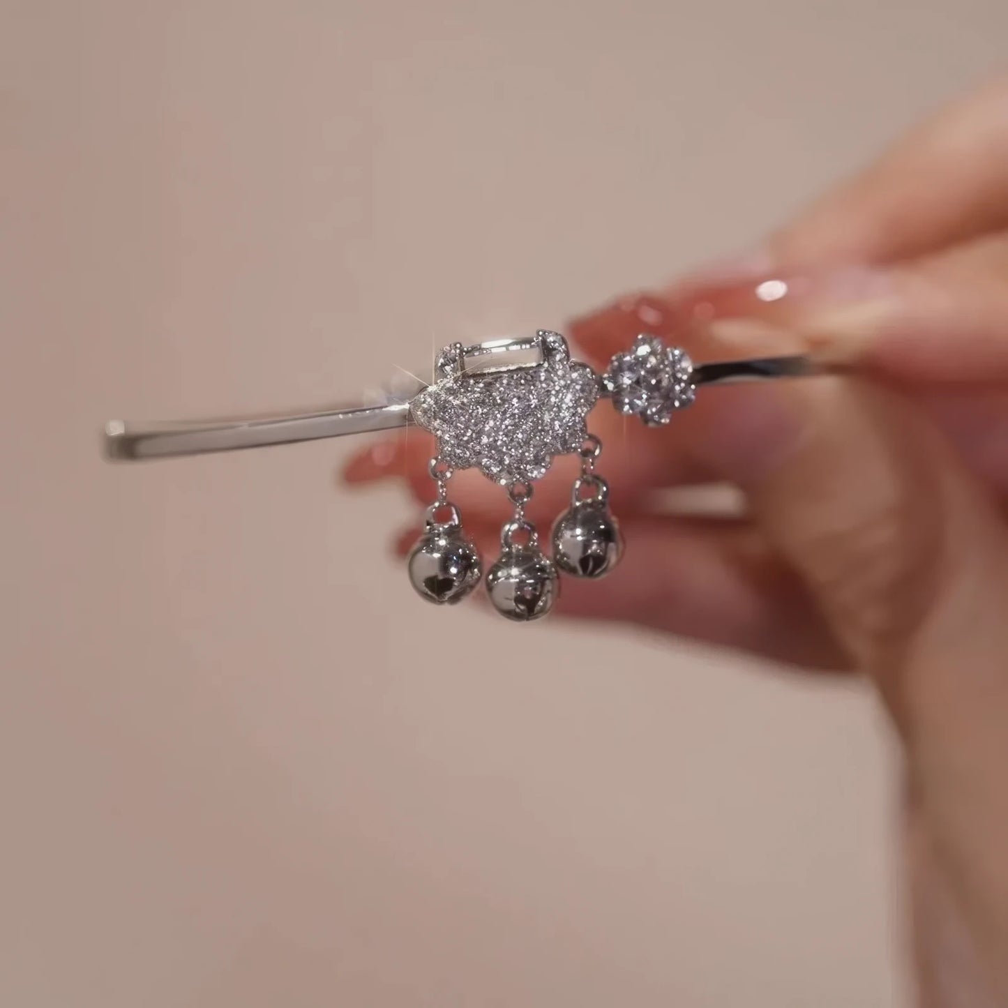 Hands holding silver safety lock bracelet, showcasing craftsmanship