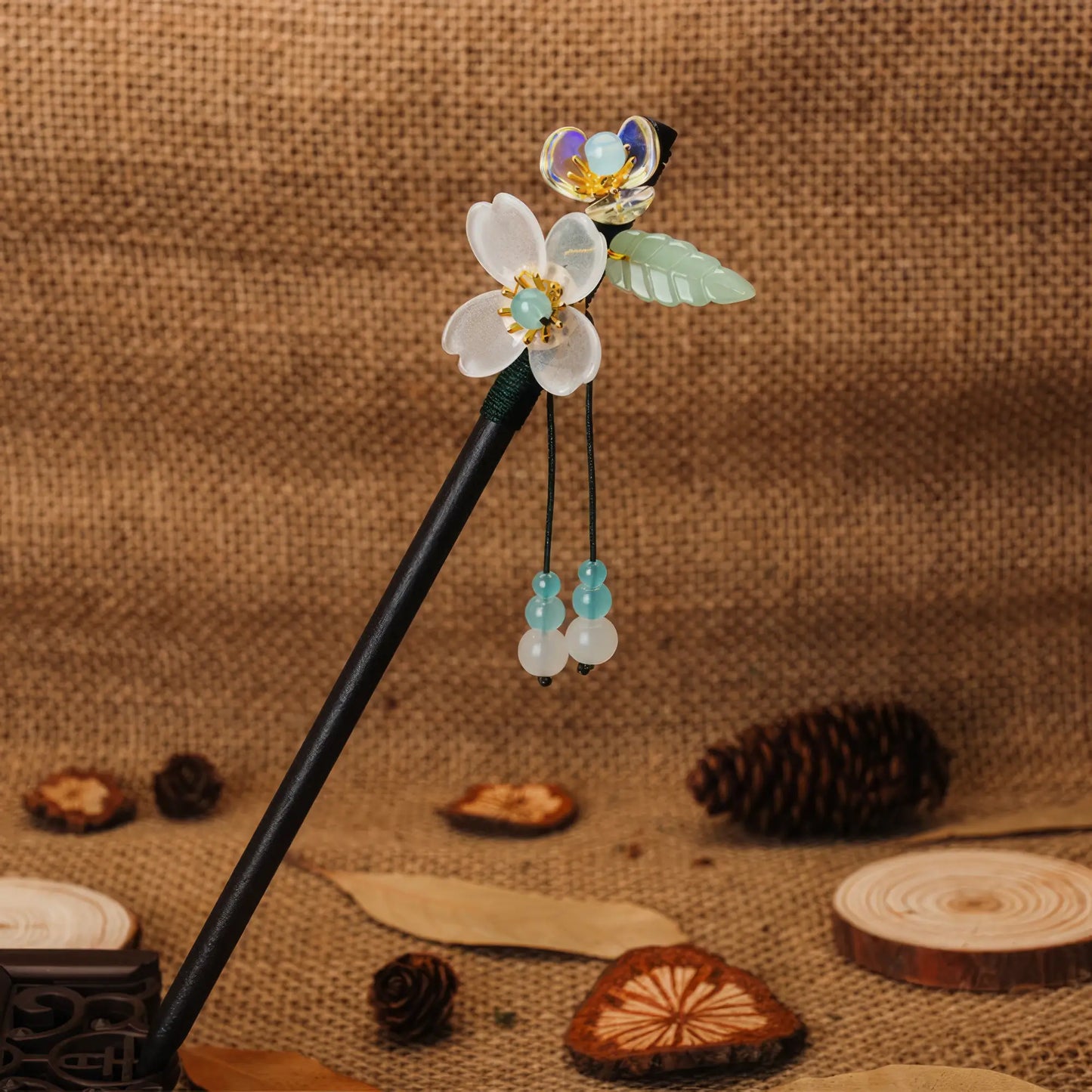 Shantaohong hairpin 6 with black rod, blue flower and blue bead tassel, linen background with pinecone and wood chips