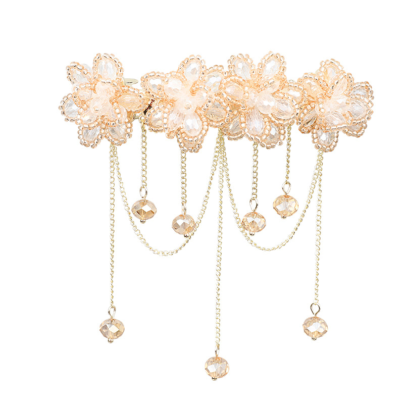 Closeup of single flower tassel barrette, light background (pearl + chain details)