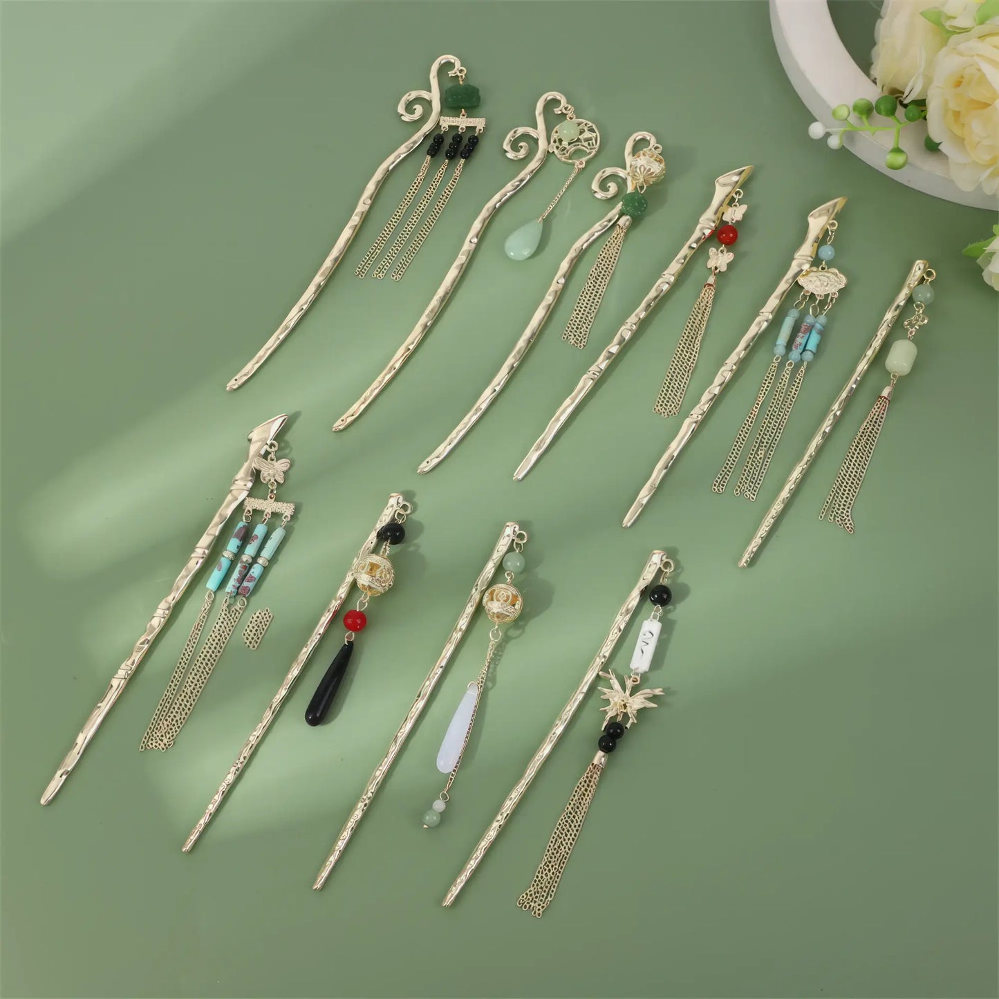 Set of Siqianlv hairpins with various tassels, gold rods, on green background