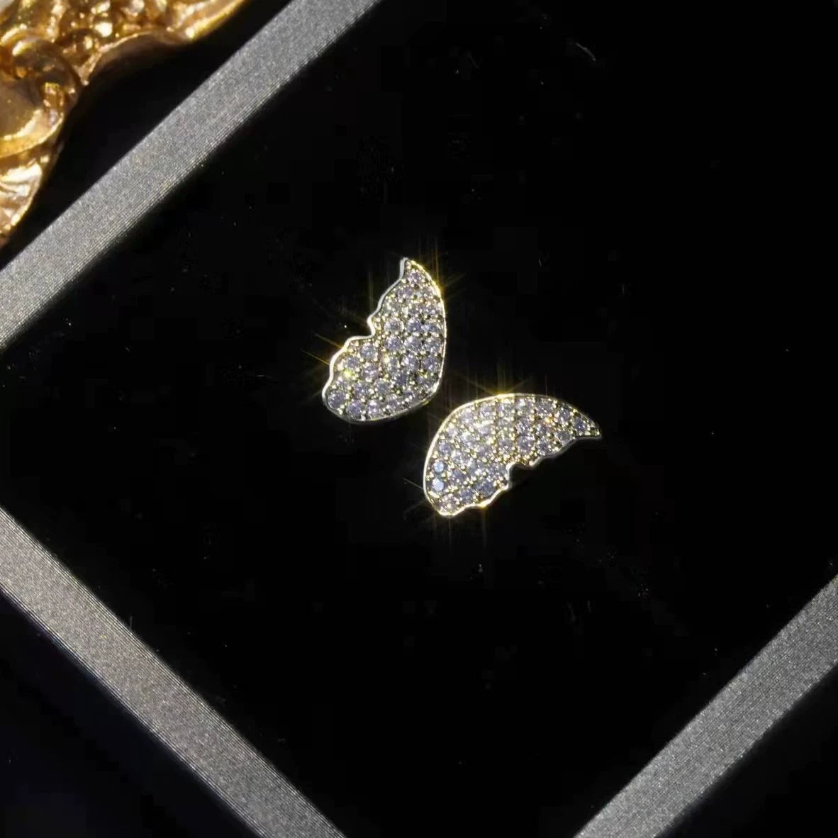 Silver two - way wear butterfly diamond earrings, placed in black box