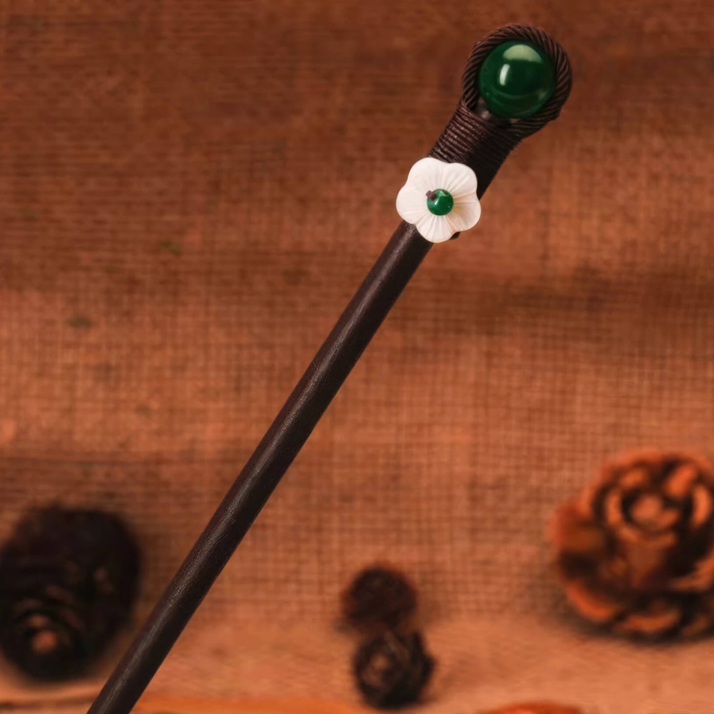 Yaotiao hairpin with green bead and white flower, brown background with pinecone and wooden elements