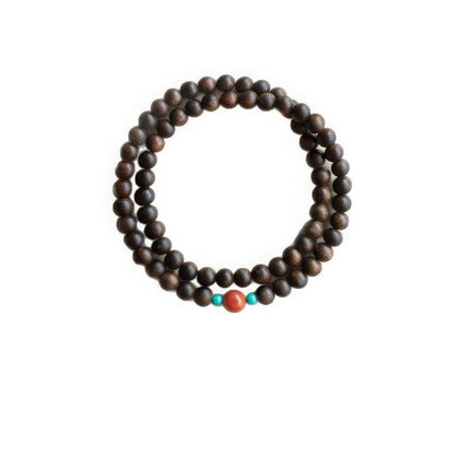 Agarwood double - layer bracelet with colorful accent beads, isolated on white background.