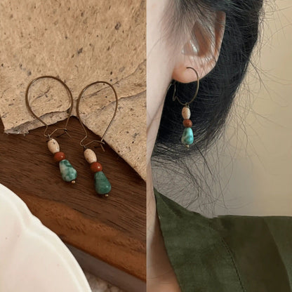 Agate picture stone pendant earrings displayed on a surface and worn, highlighting the natural and elegant appearance.