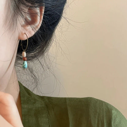 Agate picture stone pendant earring worn, complementing a green outfit, highlighting the natural and stylish look.