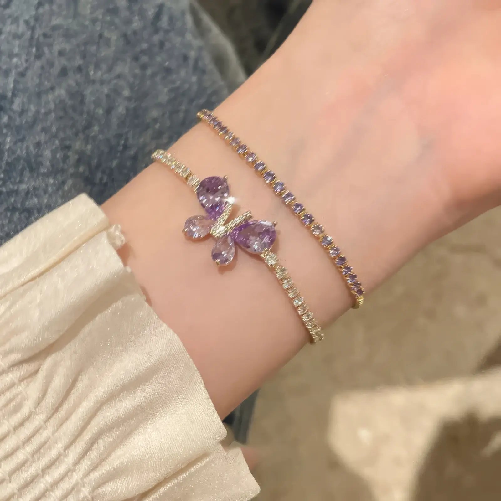  Amethyst butterfly bracelet worn on wrist, paired with another bracelet.