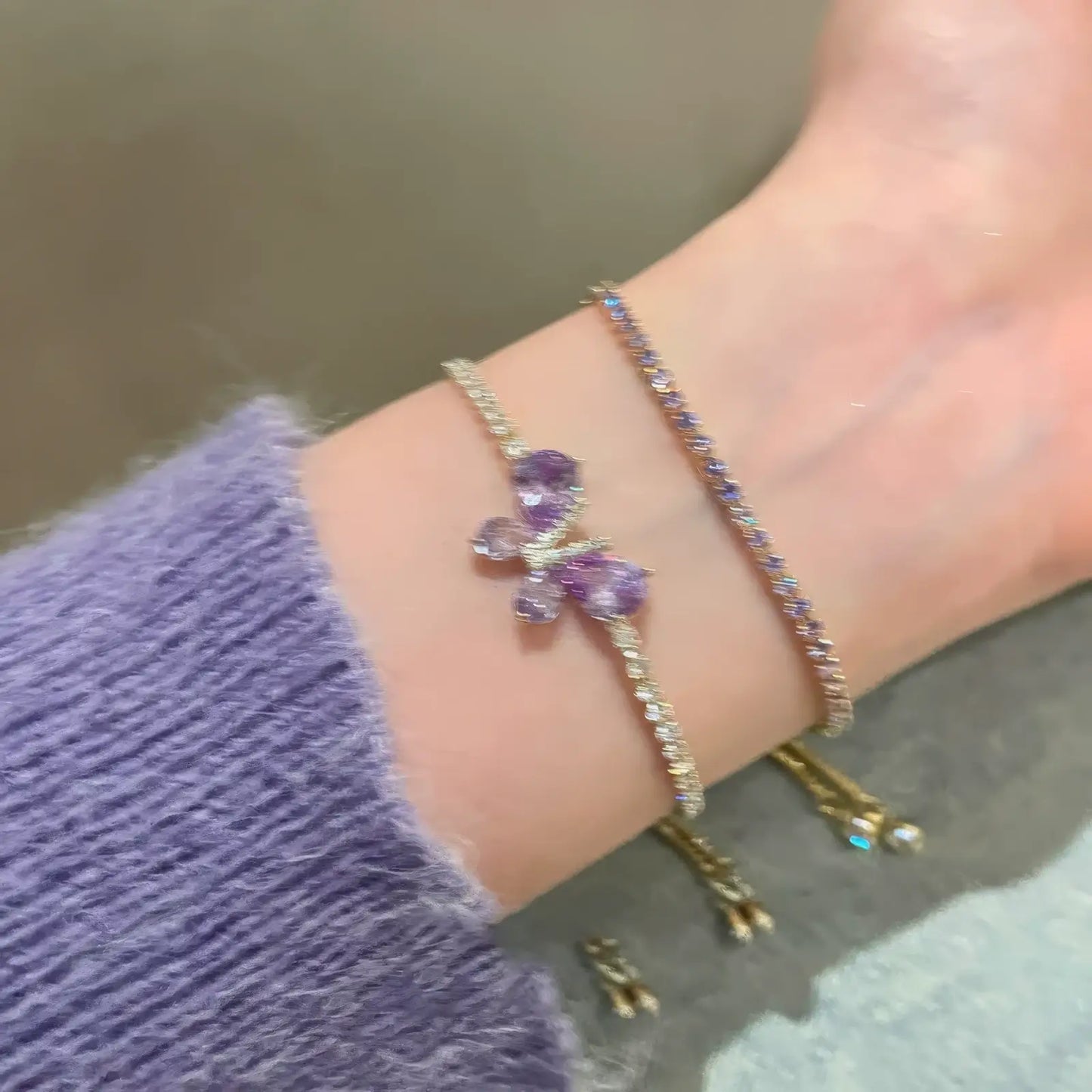 Amethyst butterfly bracelet worn on wrist, with a purple sweater sleeve.
