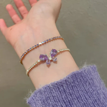  Amethyst butterfly bracelet worn on wrist, paired with another bracelet and a purple sweater sleeve.