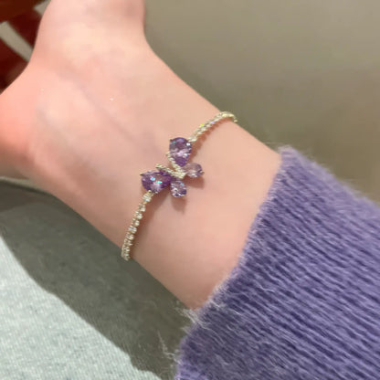 Single amethyst butterfly bracelet worn on wrist, with a purple sweater sleeve.