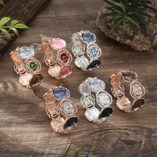 Assortment of rose - themed bracelets in different colors placed on a wooden surface.