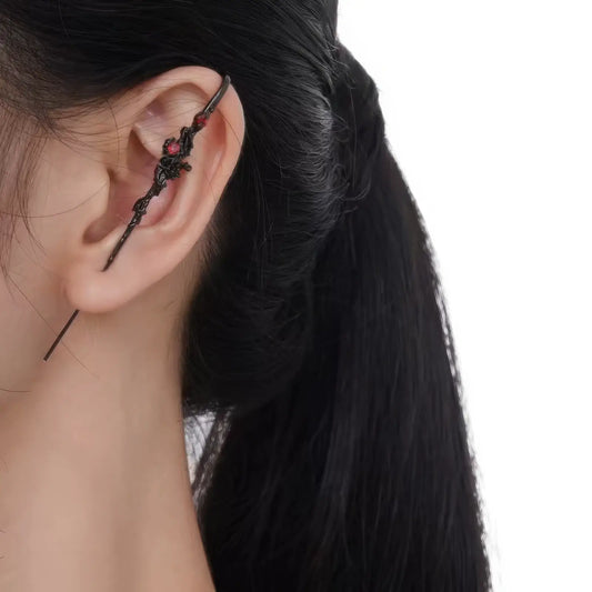 Black rose piercing ear cuff worn on ear, highlighting the detailed black rose and metalwork.