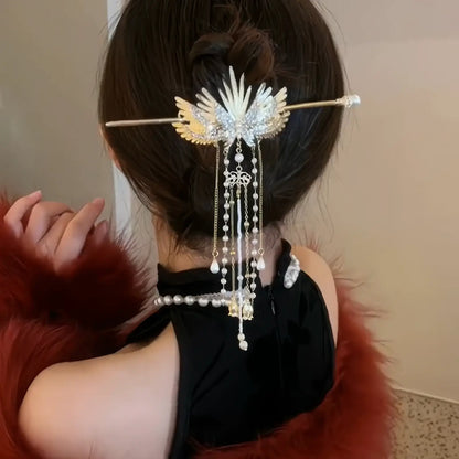 Golden wing pearl tassel hairpin used to decorate low bun hairstyle, with long cascading tassels adding romantic vintage charm.