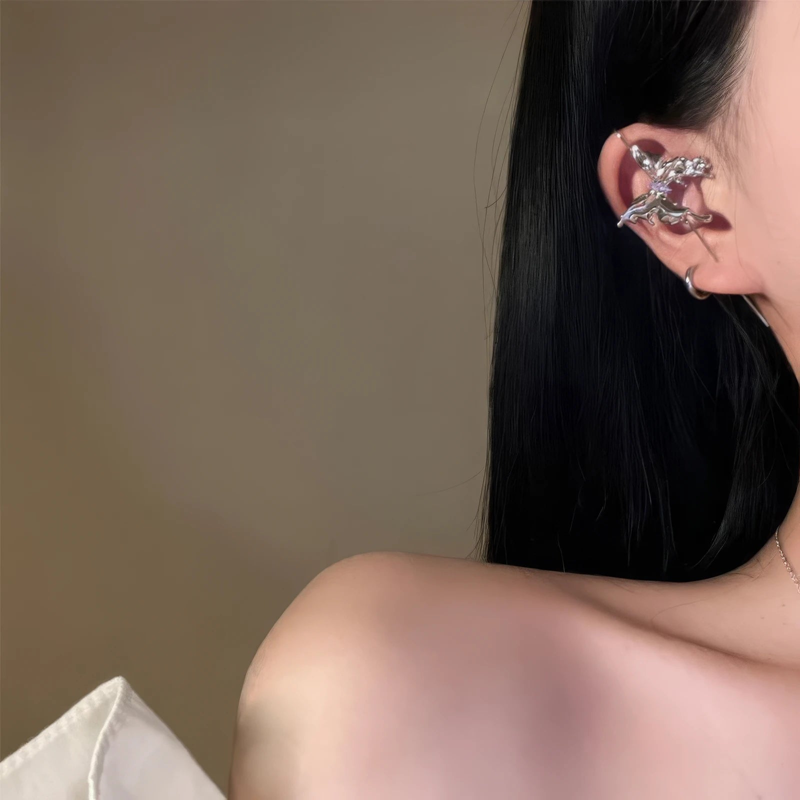 Butterfly ear cuff worn on ear, showcasing the side view of the design.
