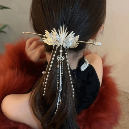 Rear close-up of angel wing hairpin securing half-tied hair, showing the layered tassel chain swinging beautifully with movement.