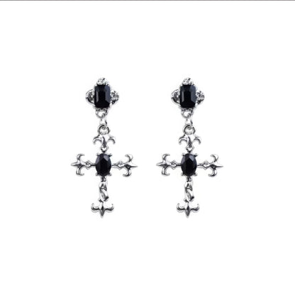 Pair of dark gem cross earrings isolated on white background