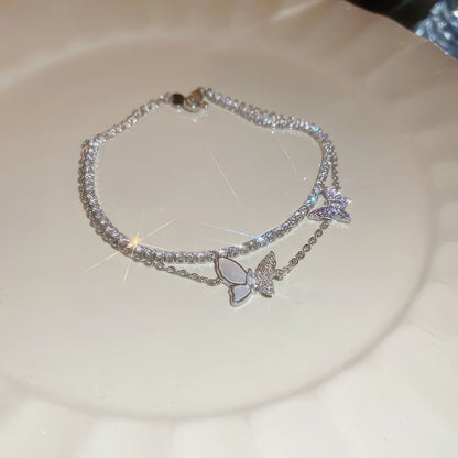 Double - layer butterfly bracelet placed on a white plate.
